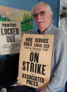 Former Wire Service Guild President Malcolm Barr Sr. holds signs from 1969 strike against AP.