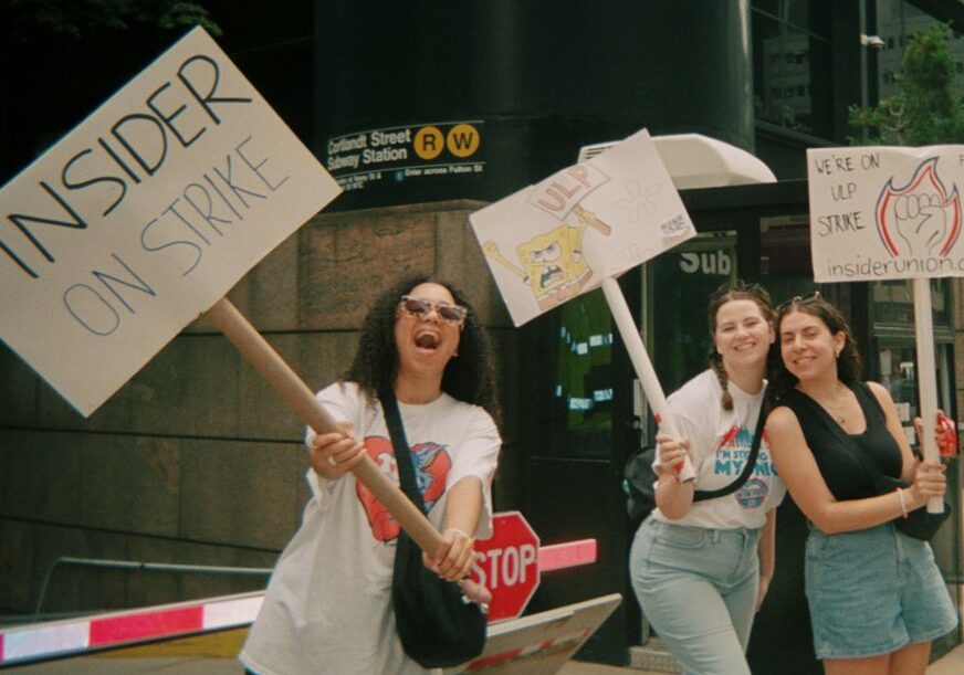 Photo of three women holding picket signs: Insider Union members at the picket line in lower Manhattan who struck for 13 days in June 2023