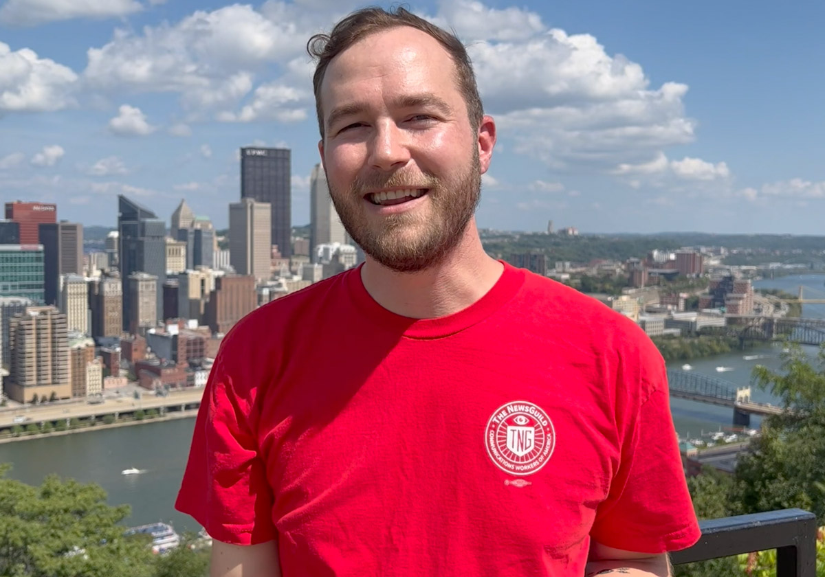 Photo of Jon Schleuss in front of Pittsburgh skyline