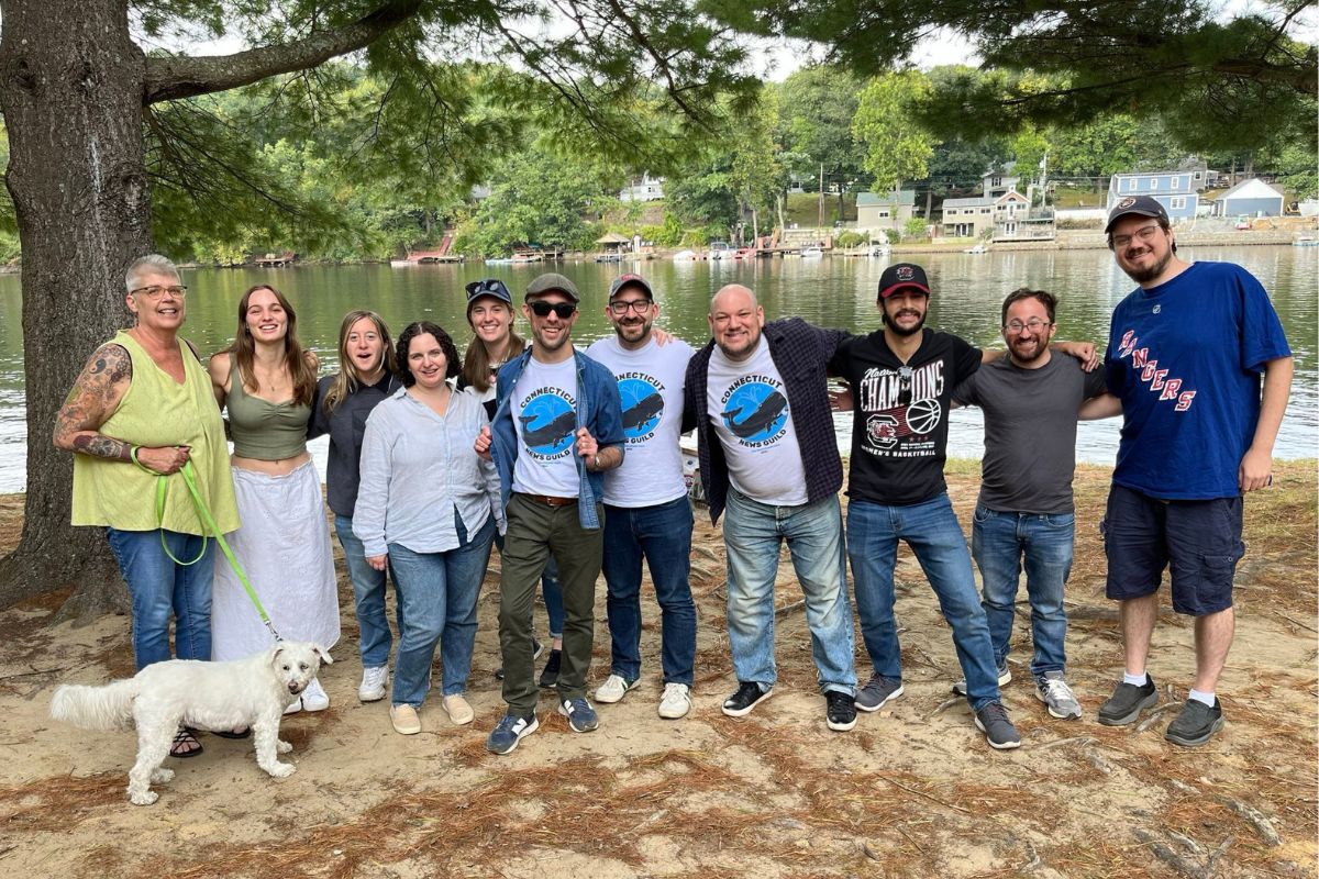 Hearst guild members stand arm in arm at a picnic outside.