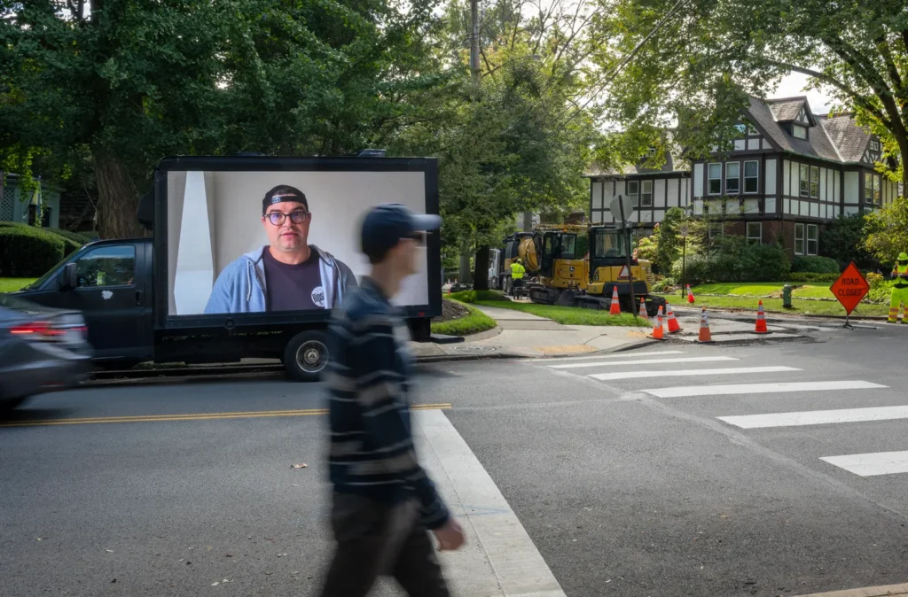 The video image of striking PG worker John Santa illuminates the intersection of Ellsworth Avenue and Devonshire Street, near PG publisher John Block’s Shadyside home, on Tuesday, Oct. 8, 2024. Strikers delivered messages of solidarity on the billboard truck to mark the strike’s two-year anniversary. (Steve Mellon/Pittsburgh Union Progress)