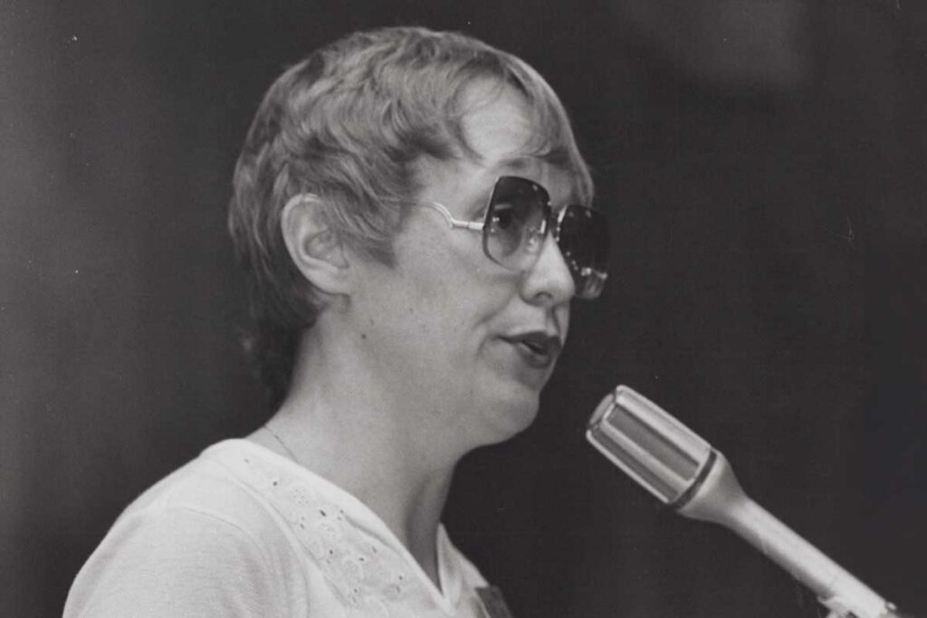 Photo of Carol Rothman speaking at a microphone
