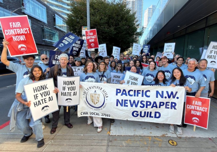 Workers at the Seattle Times hold signs and banners during their informational picket